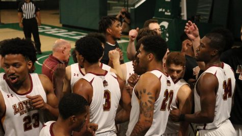 The mens basketball team strategize in a huddle during their game against North American University on Oct. 23, 2021