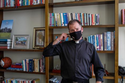 The Rev. Justin Daffron, S.J. stands in front of his bookshelf in his office on Feb. 14, 2021. Daffron is interim president after former president Tania Tetlow left the position in the summer of 2022. 