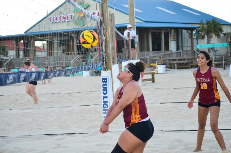 Vasquez goes for the ball on the beach court wearing cool shades and facing the net