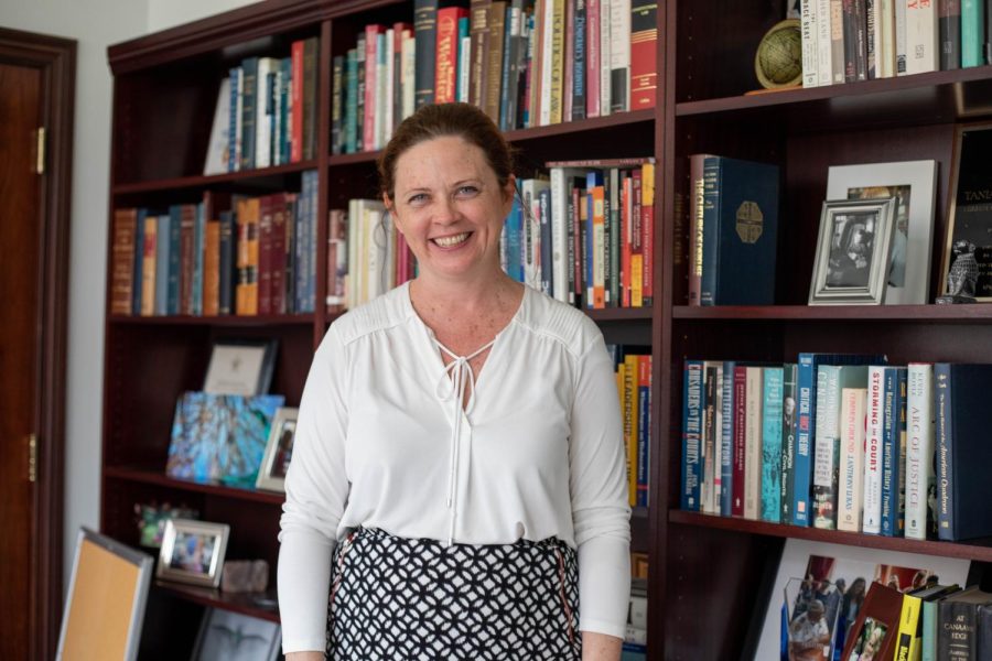 President Tania Tetlow stands in front of her bookcase in her office on the second floor of Marquette Hall on Feb.16, 2022. Tetlow is leaving Loyola at the end of the semester to be Fordham’s first female, layperson president. 