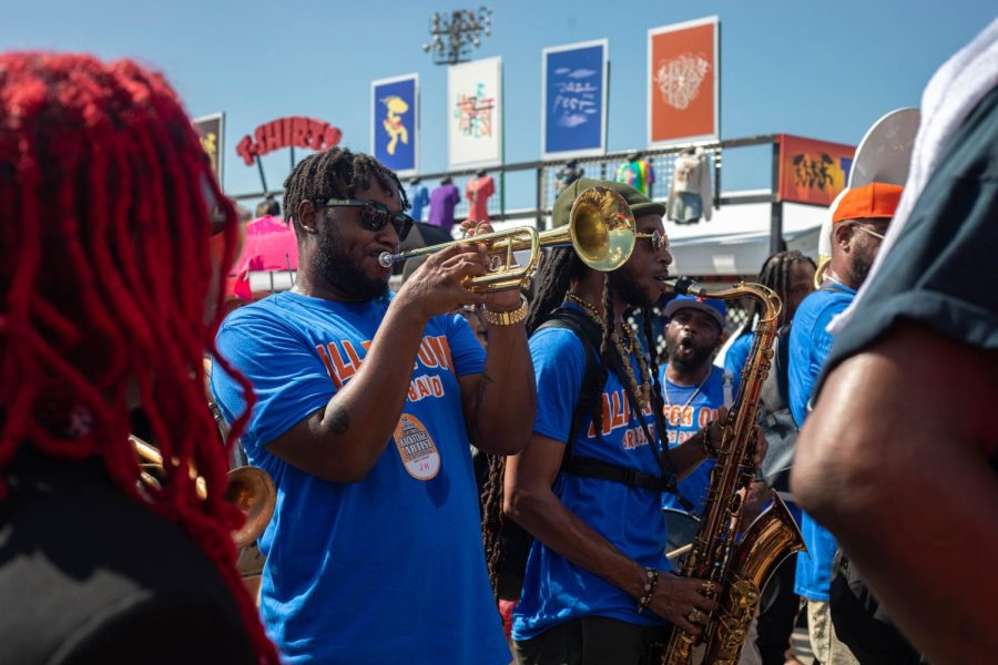 Performers play trumpet and saxophone during a second line parade at Jazz Fest Sunday May 1, 2022. Parades during Jazz Fest included many members of the community, local performers, and Mardi Gras Indians.