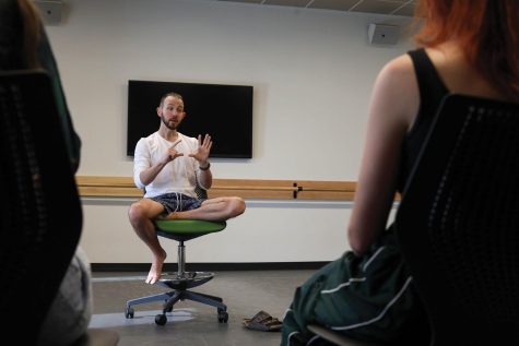 man sits on chair in front of students