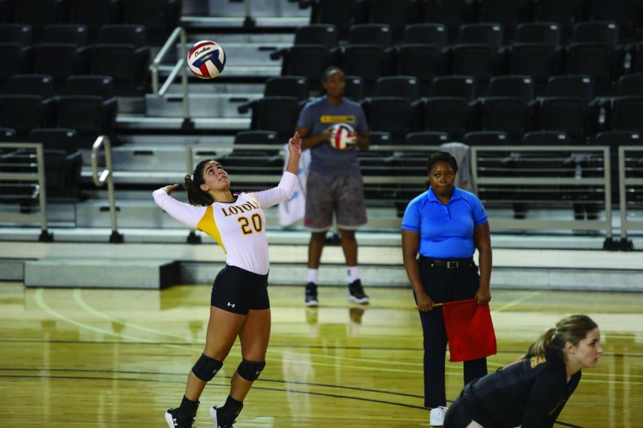 Volleyball player has a hand up ready to spike a ball coming toward her