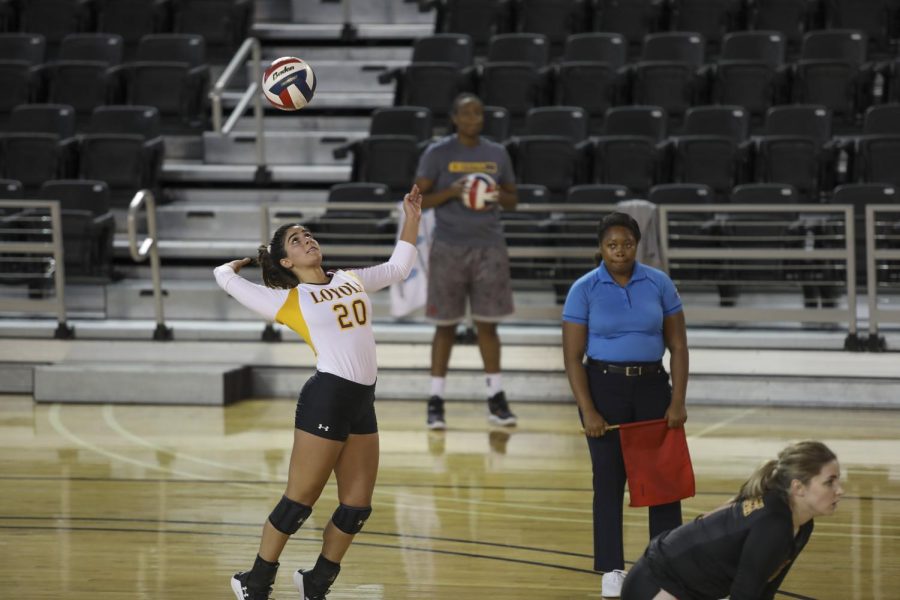 A volleyball player prepares to spike a ball coming toward her