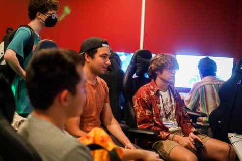 A group of students sit in the new esports facility playing video games