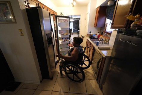 person in wheelchair looking in fridge
