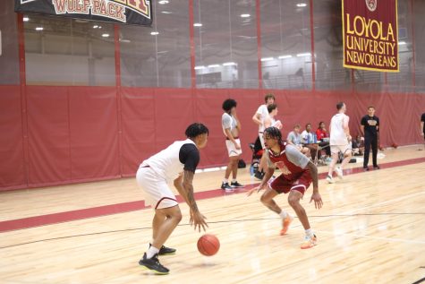 Two basketball players practice passing at a scrimmage in the Loyola gym.