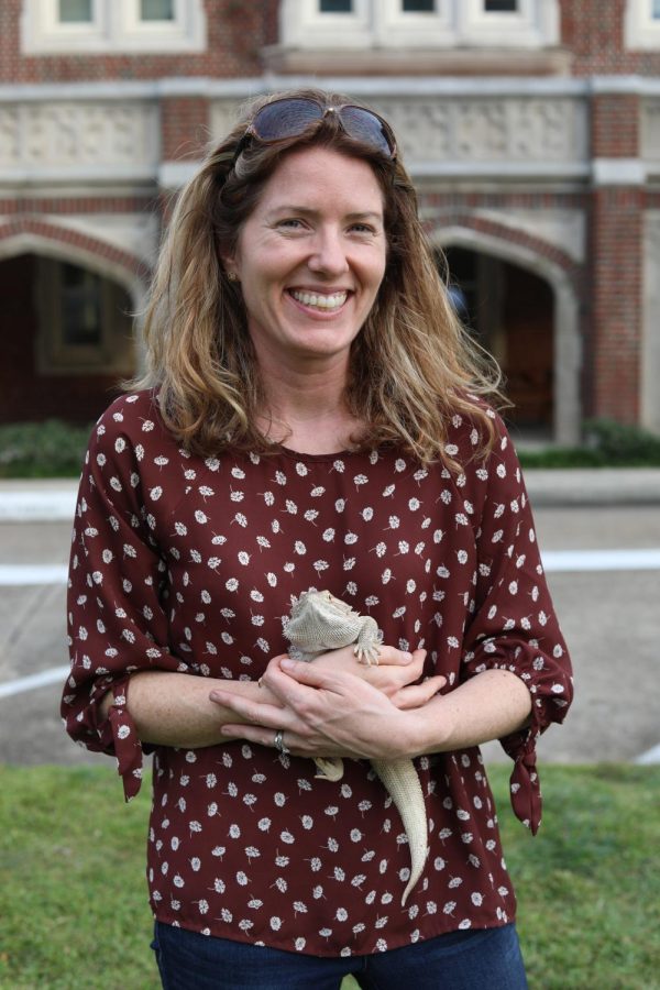 A lady hold a bearded dragon in her arms