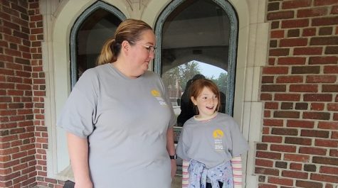 A mom and daughter stand side-by-side wearing volunteer shirts.