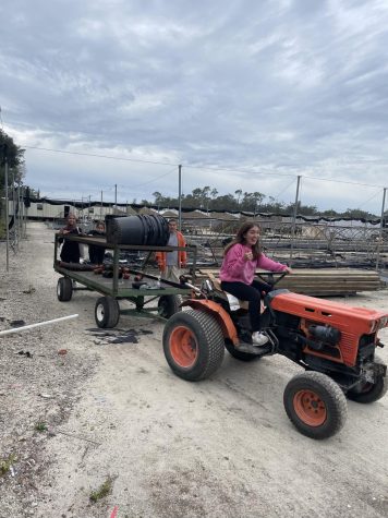 A Loyola student rides a tractor whilst working on the 2023 Ignacio Volunteer trip.