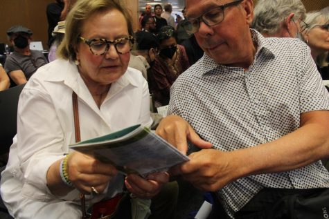 Two attendants read through an itinerary.