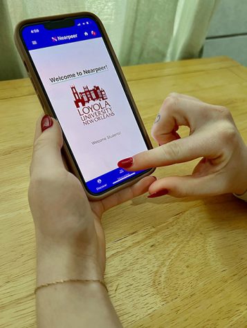 Student holds up phone with the Nearpeer app opened.