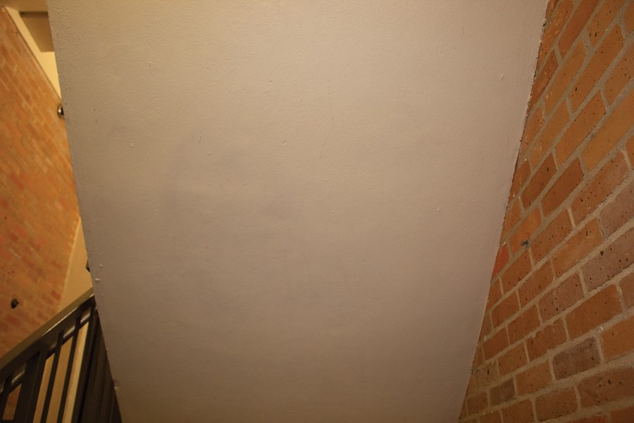 Photo of the painted previously vandalized wall that reads fuck reslife below the fresh coat of paint.