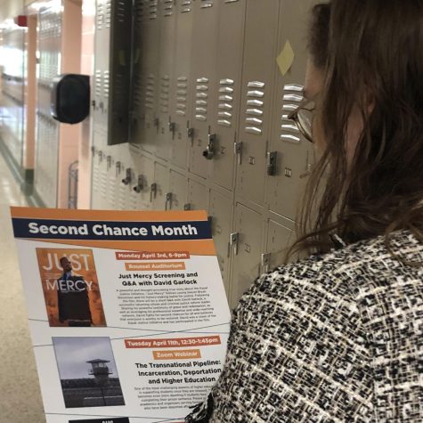Student reading the Jesuit Social Research Institute poster for events.