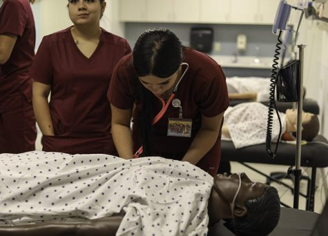 Nursing students practice taking vitails on a medical test dummy in Monroe Hall on Aug. 25, 2022. 
