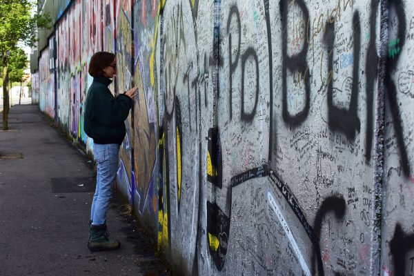 Ruby Zlotkowski at the Peace Wall in Belfast, Northern Ireland while on the Loyola Study Abroad trip, July 2023. Peace be with you, she wrote. 

