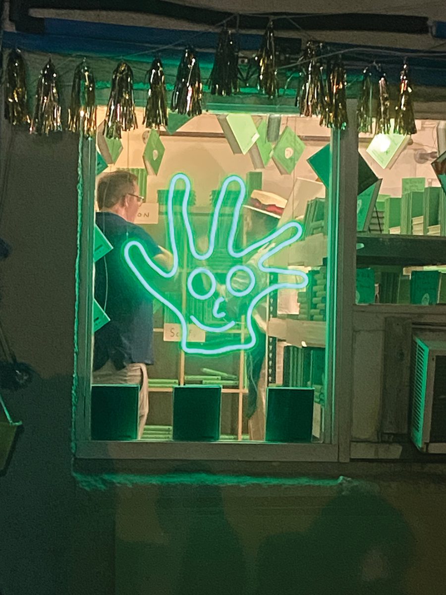 A+BIG+green+hand+neon+sign+hangs+outside+90s+Kids+Closet+in+Uptown+New+Orleans+on+Sept.+26%2C+2023.+Author+Mathew+Gray+Gubler+did+a+surprise+visit+to+the+shop+to+showcase+his+new+book+and+meet+fans.