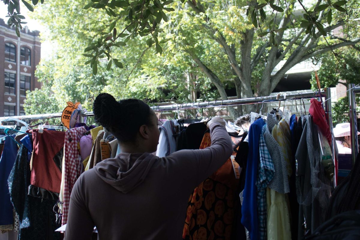 Student browses through the racks of the Loyola costume shop. All costumes are made from sustainable material.