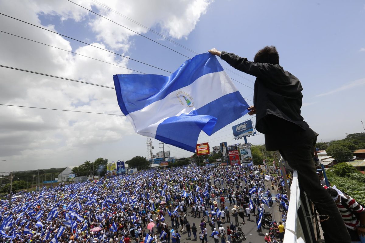 A man waves a Nicaraguan flag as people participate in a demonstration called the March of the Flowers remembering the children killed during the last two-months violence, in Managua, Nicaragua, Saturday, June 30, 2018. The Central American nation has been rocked since April 19 by daily chaos as protesters maintaining roadblocks and demanding Ortegas ouster are met by a heavy-handed crackdown by security forces and allied civilian groups.