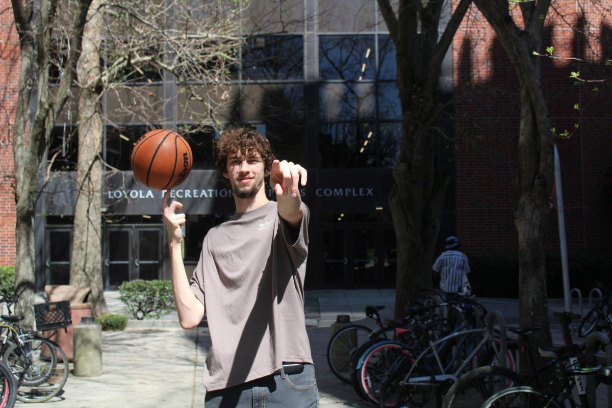 Sophomore basketball player Brody Adams spins ball in front of sports complex.
