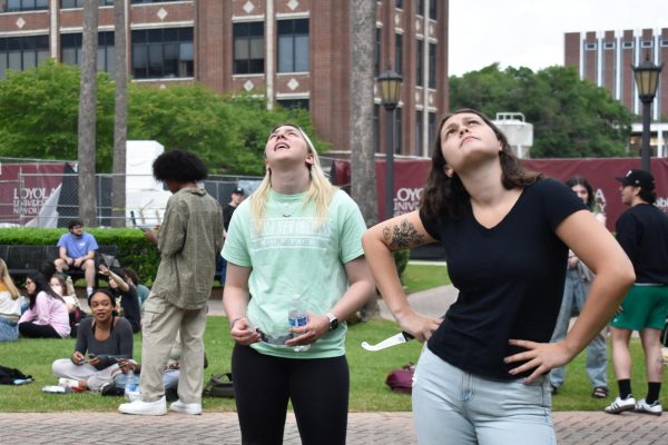 Freshman Rebecca Doherty (right) views the solar eclipse in the Palm Court on April 8, 2024.