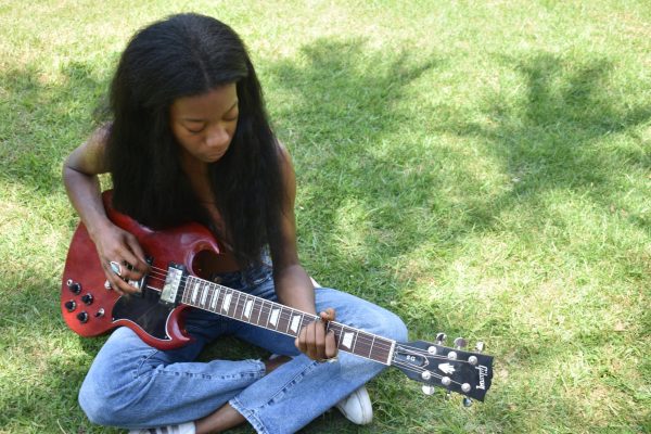 Music industry senior Noa Jamir plays guitar in the Palm Court on April 23, 2024.