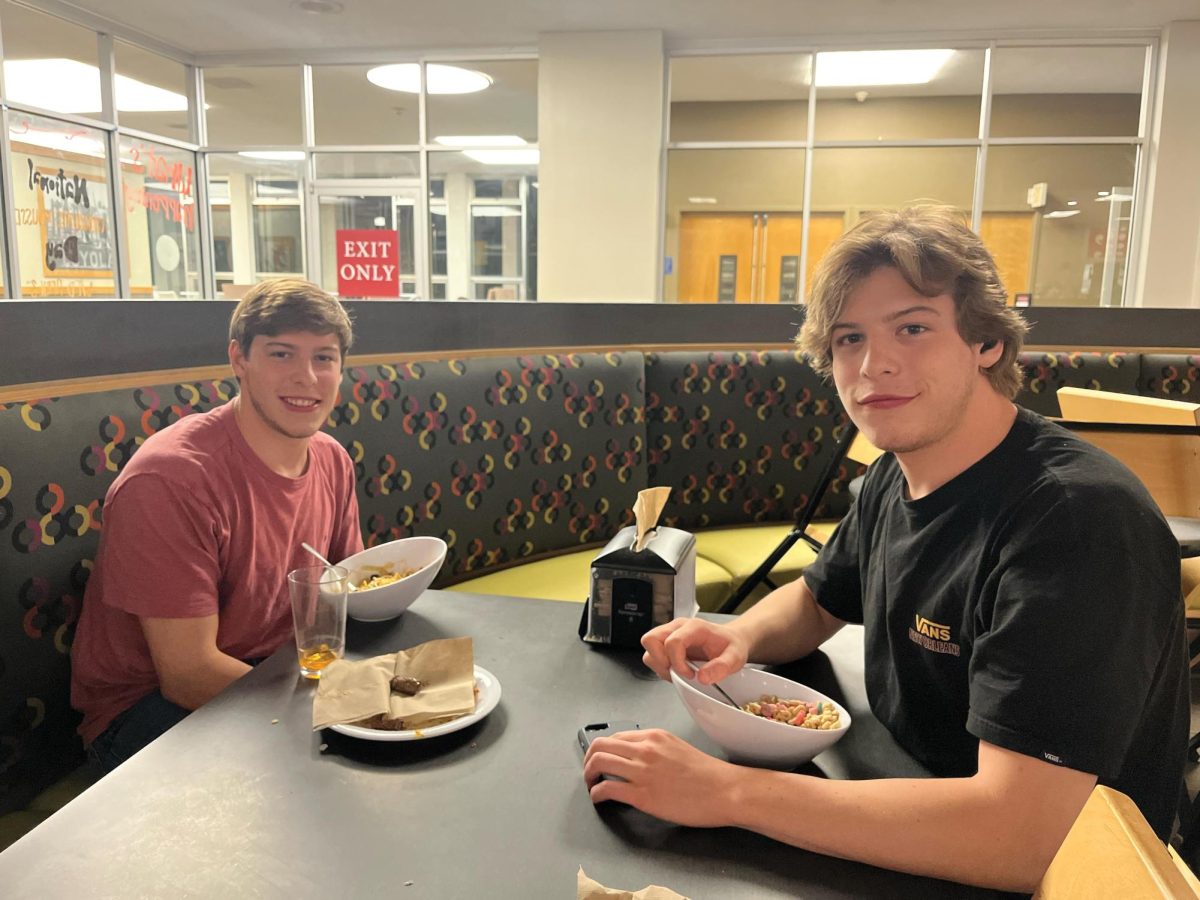 Twins Ben Chehebar (left) and Dylan Chehebar (right) eat dinner together in the Orleans Room on April 4, 2024. The twins are members of the Loyola swim team.