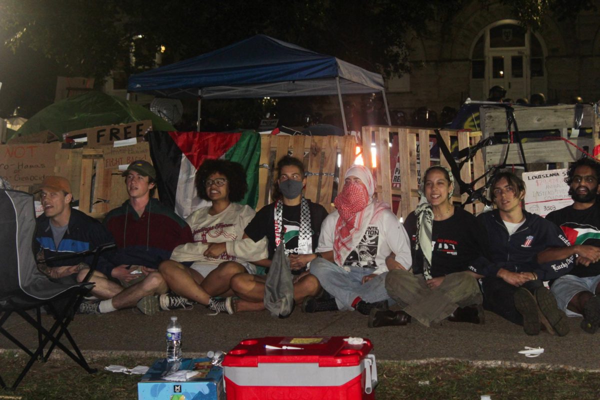 Student protesters resist a police sweep by sitting around the encampment structure with their arms interlocked around 3 a.m. on May 1. SWAT arrested all 11 protesters soon after. 