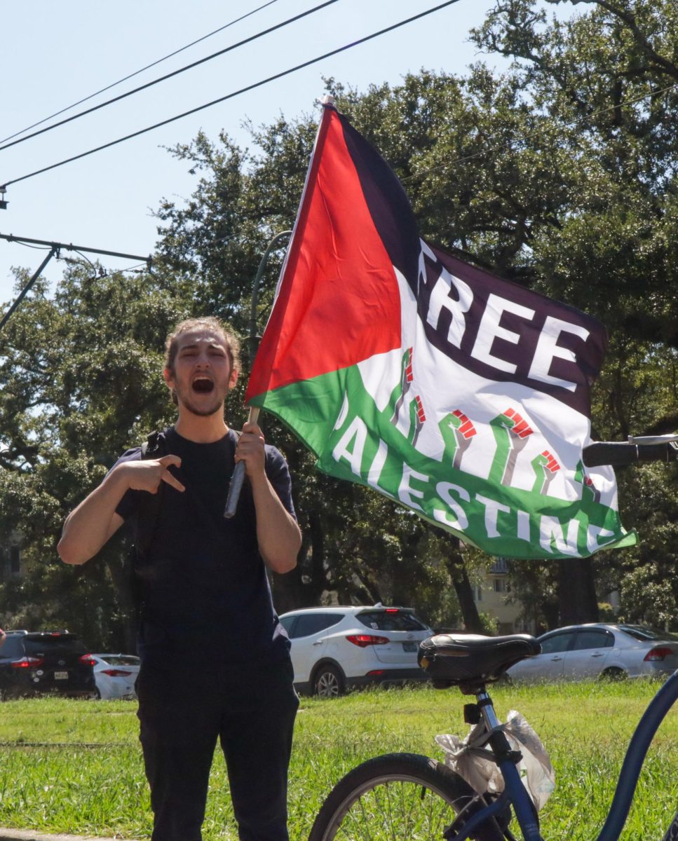A pro-Palestinian protester waves a "Free Palestine" flag on St. Charles Avenue on Oct. 7, 2024. This rally was held on the one year anniversary of the Israel-Hamas war resurgence.