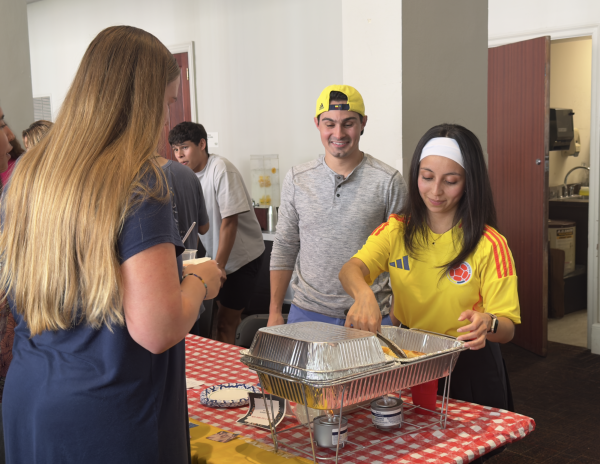 Students representing Colombia serve
food.