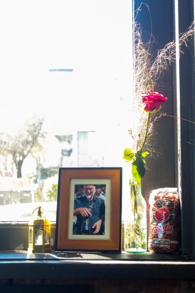 Framed photo of Johnson alongside a rose and red beans to honor him. The photo is beside a bag of red beans to honor Johnson's red bean dinners. Feb. 17, 2025. 