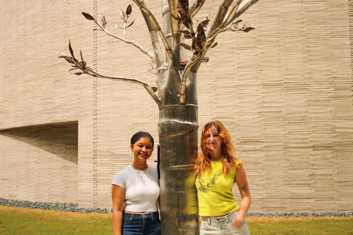 Kristen Goodly and Mimi Ryall stand with The Kendall Collective, a tree sculpture made to honor Kendall Daigle. Goodly and Ryall are a part of the petition to name the area around it Kendall Court.  