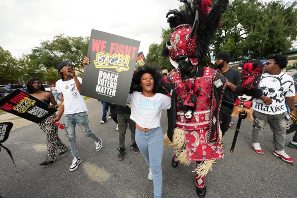 Students and a member of the Zulu Tramps march to a campus polling place on Election Day at Southern University in Baton Rouge, La., Nov. 5, 2024.