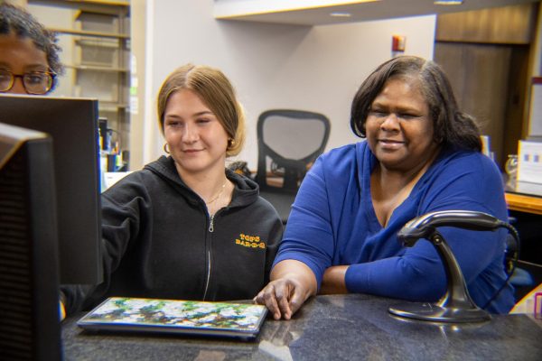 Isa Crownover and Evonne Lawrence use a computer at the front desk of Monroe
Library.