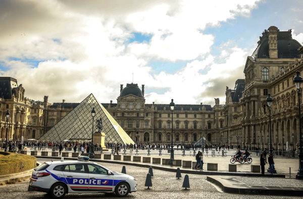 A police car parks in the courtyard of the Louvre museum, one week after the robbery, Sunday, Oct. 26, 2025 in Paris. The Paris prosecutor said on Sunday that a number of suspects have been arrested over the theft of crown jewels from Paris' Louvre museum last weekend. (AP Photo/Thomas Padilla)