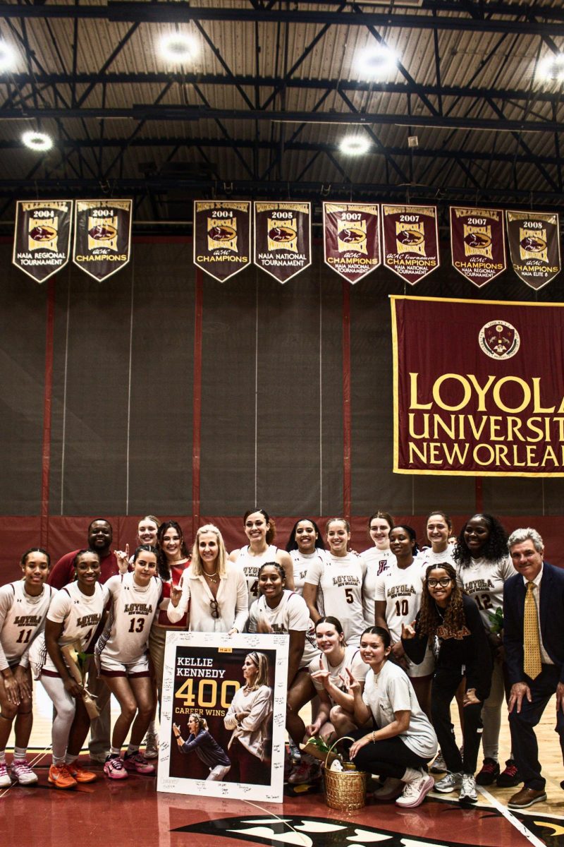 Coach Kelly Kennedy posing with her 400 career sign along with her basketball player. she has been at Loyola for 18 years. Courtesy Heidi Herrera- Wanke